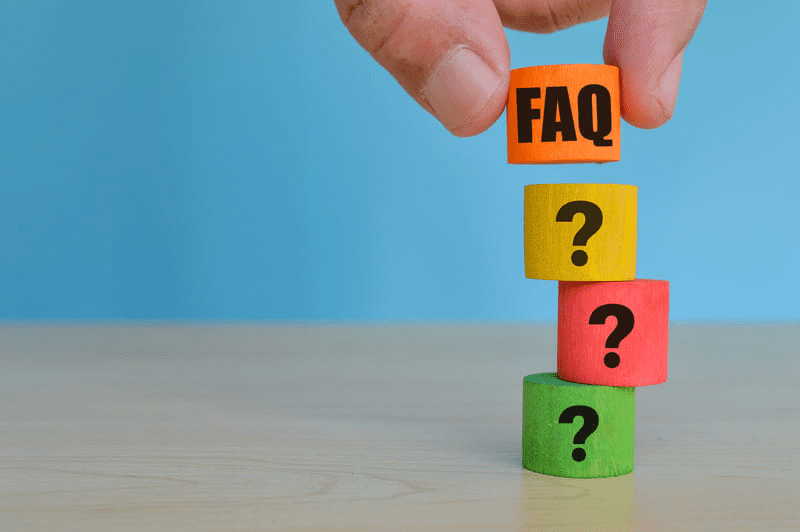 a hand stacking colorful blocks with question marks